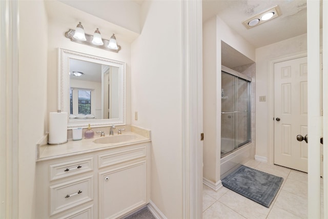 bathroom featuring baseboards, bath / shower combo with glass door, vanity, and tile patterned flooring