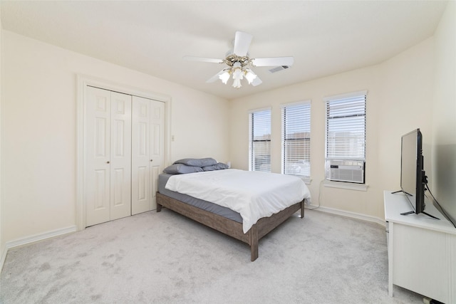 bedroom with a closet, visible vents, light colored carpet, and cooling unit