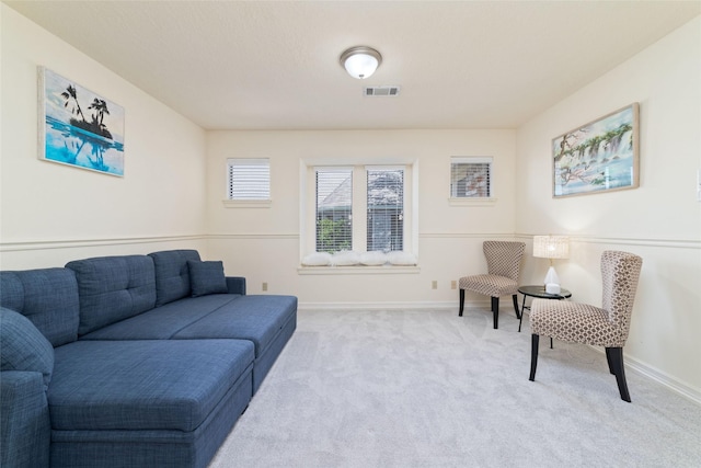 living area featuring visible vents, carpet flooring, and baseboards