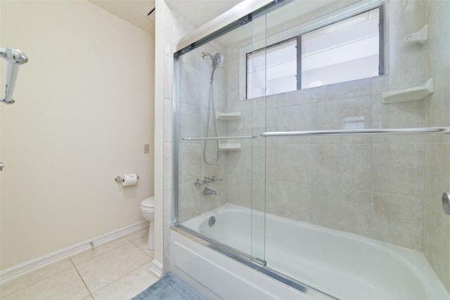 full bathroom featuring tile patterned floors, toilet, baseboards, and shower / bath combination with glass door