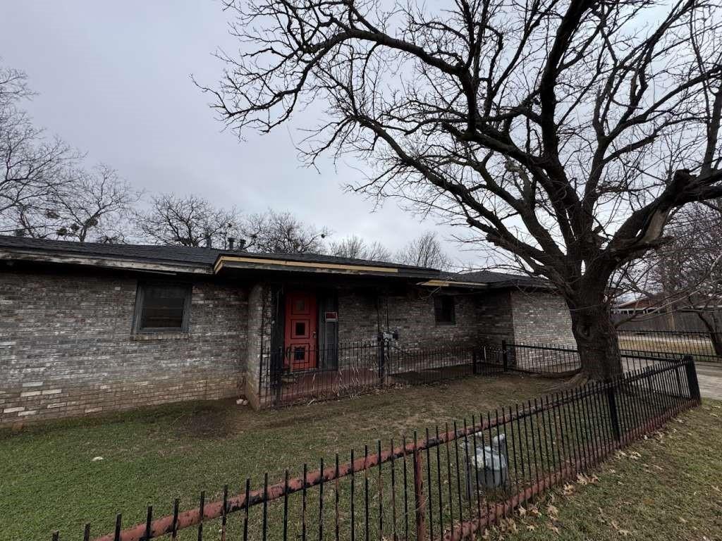 300 E Ida Ave, Electra, TX 76360 - view of front of house with brick siding, a front lawn, and fence