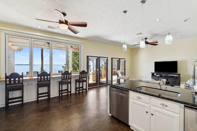 kitchen featuring a sink, finished concrete flooring, white cabinetry, dishwasher, and ceiling fan