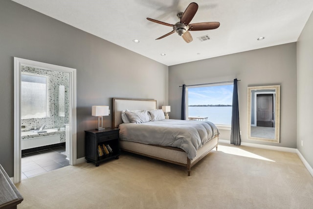 tiled bedroom with baseboards, visible vents, ensuite bath, a water view, and carpet flooring