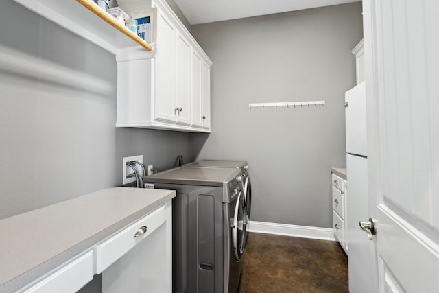 laundry area with cabinet space, baseboards, and washing machine and clothes dryer