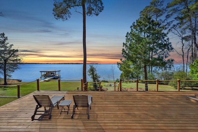 deck with a lawn, a water view, and a boat dock