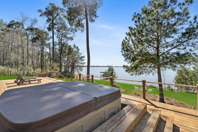 wooden deck with a lawn, a hot tub, and a water view