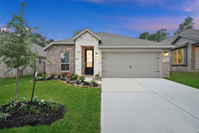 view of front of house with driveway, stone siding, a garage, a lawn, and brick siding