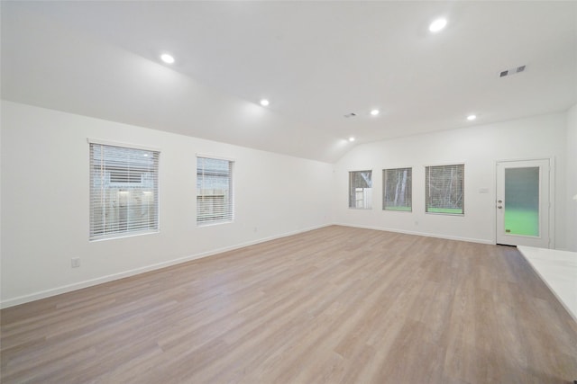 empty room featuring vaulted ceiling, recessed lighting, light wood-type flooring, and visible vents