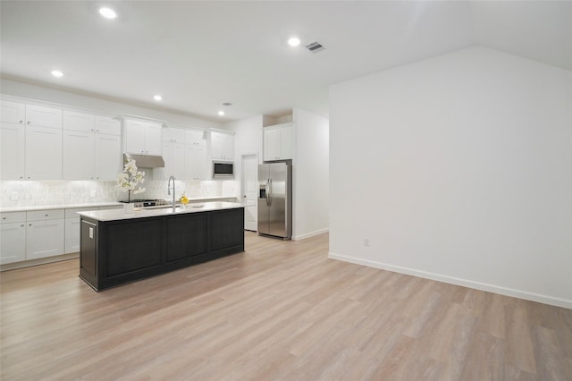 kitchen with backsplash, light wood-type flooring, light countertops, stainless steel appliances, and white cabinetry