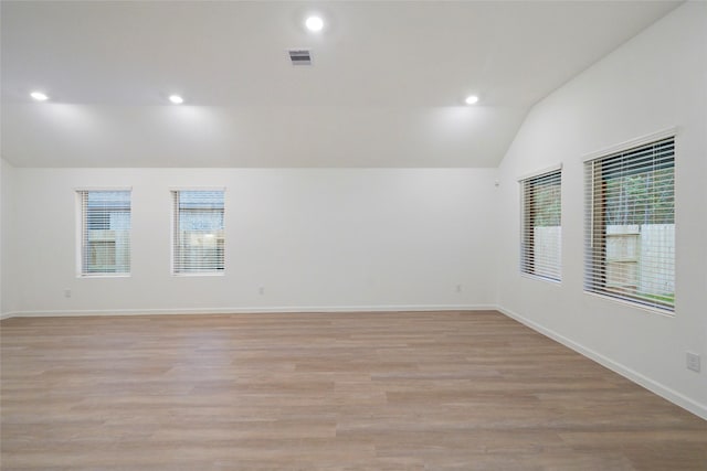 empty room with baseboards, visible vents, recessed lighting, vaulted ceiling, and light wood-type flooring