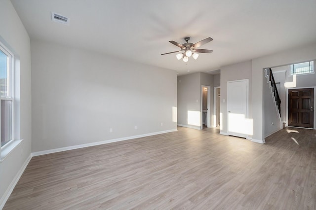 spare room featuring light wood-style flooring, baseboards, visible vents, and ceiling fan