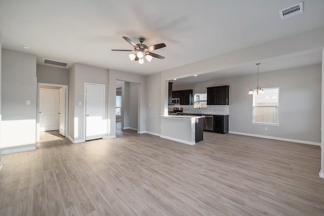 unfurnished living room with visible vents, light wood-style flooring, baseboards, and a ceiling fan