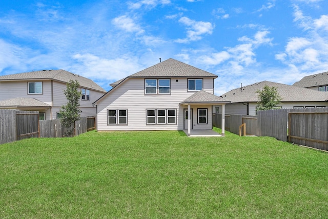 back of house with a yard, a patio area, a fenced backyard, and a shingled roof