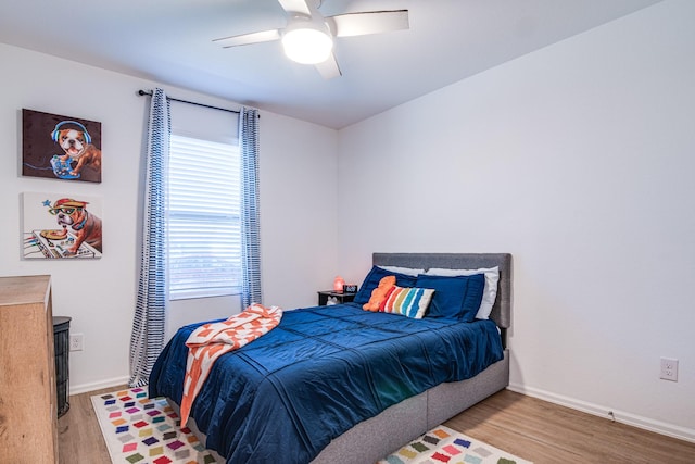 bedroom featuring baseboards, ceiling fan, and light wood finished floors