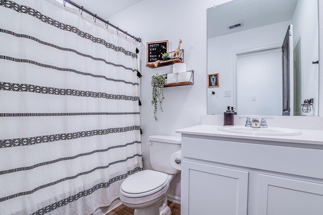 bathroom featuring a shower with shower curtain, visible vents, toilet, and vanity