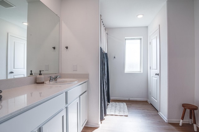 full bath featuring visible vents, baseboards, a shower with curtain, wood finished floors, and vanity