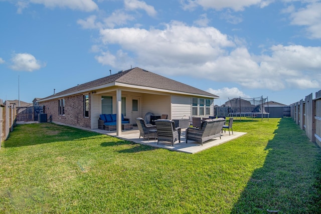 rear view of house with an outdoor living space, a trampoline, a patio area, and a fenced backyard