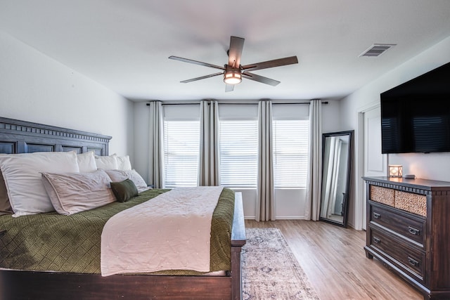 bedroom with light wood-type flooring, visible vents, and a ceiling fan