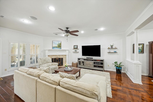 living room with decorative columns, dark wood-style flooring, a ceiling fan, and crown molding