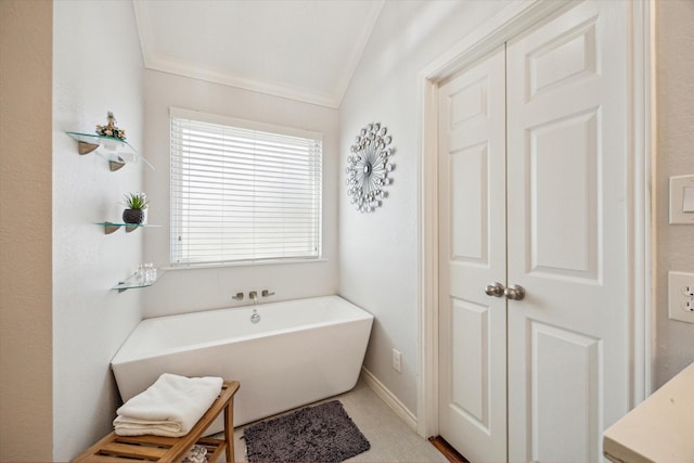 full bathroom featuring tile patterned flooring, ornamental molding, baseboards, and a freestanding tub