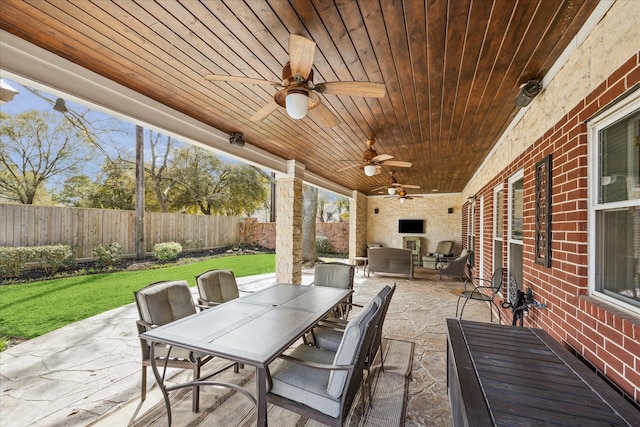 view of patio with outdoor dining space, ceiling fan, and a fenced backyard