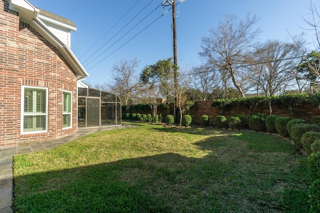 view of yard with glass enclosure and a fenced backyard