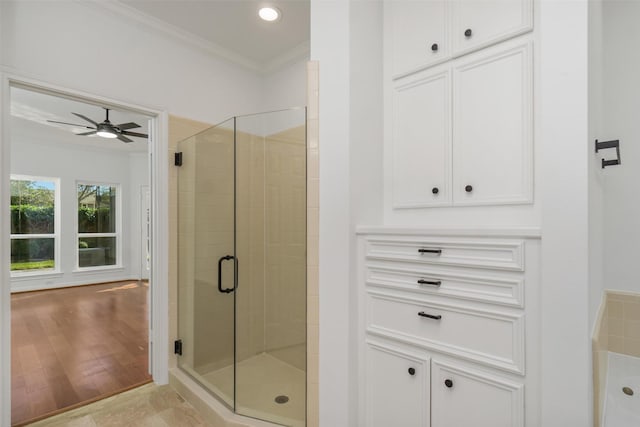 full bathroom with a stall shower, wood finished floors, ornamental molding, and ceiling fan