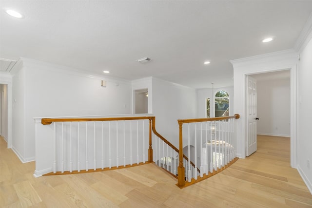 hall featuring wood finished floors, recessed lighting, an upstairs landing, and ornamental molding