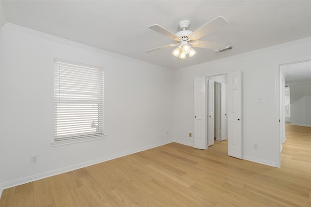 unfurnished bedroom featuring visible vents, light wood-style floors, and crown molding