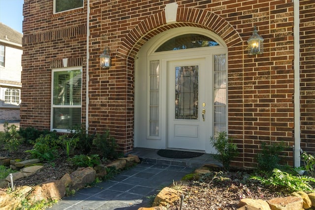 entrance to property featuring brick siding