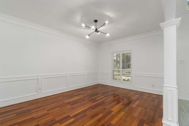 unfurnished room featuring a notable chandelier, wood-type flooring, ornate columns, and ornamental molding