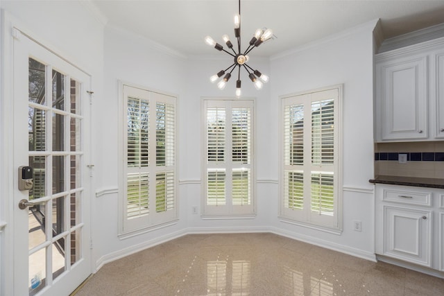 unfurnished dining area with ornamental molding, baseboards, and a chandelier