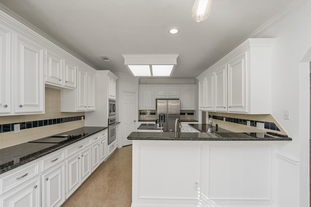 kitchen featuring stainless steel appliances, visible vents, white cabinets, and dark stone counters