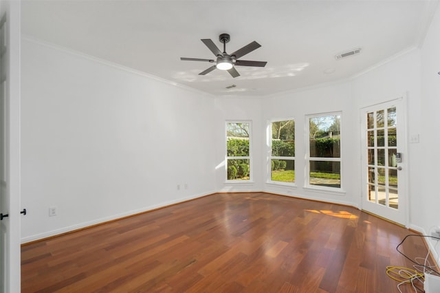 empty room featuring baseboards, crown molding, ceiling fan, and wood finished floors