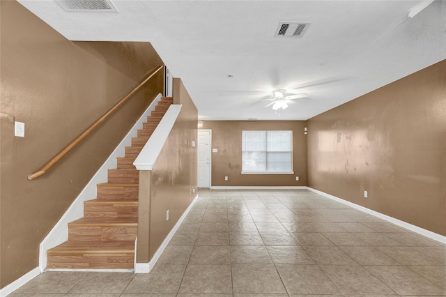 interior space featuring stairs, a ceiling fan, visible vents, and baseboards