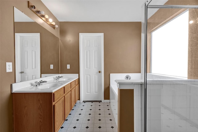 full bath featuring a sink, a bath, double vanity, and tile patterned floors