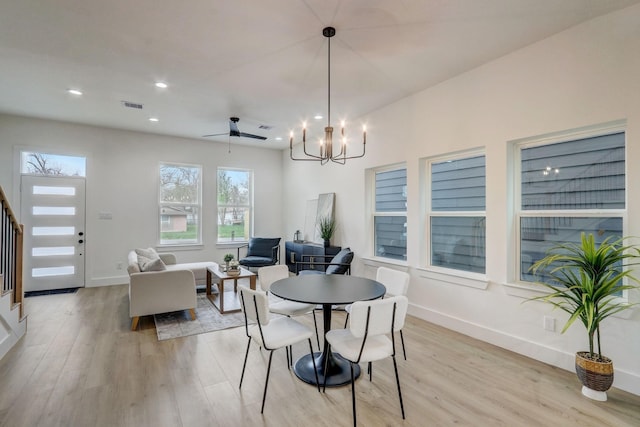 dining space featuring light wood finished floors, visible vents, baseboards, and an inviting chandelier