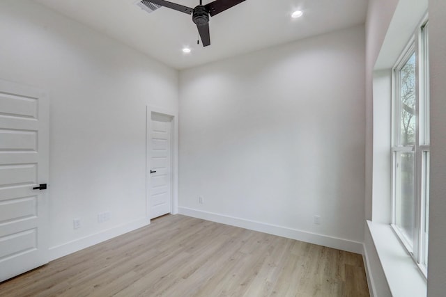 empty room with visible vents, baseboards, light wood-style floors, and a ceiling fan