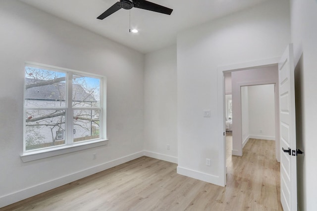 empty room with recessed lighting, a ceiling fan, baseboards, and light wood finished floors