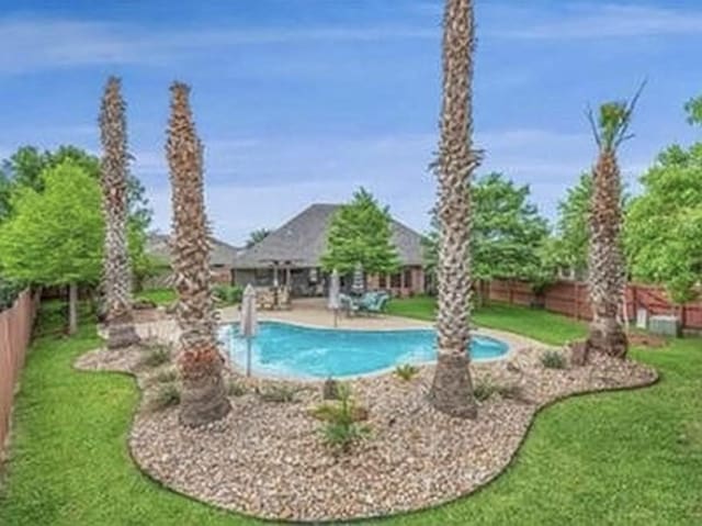 view of pool with a fenced in pool, a lawn, a fenced backyard, and a patio area