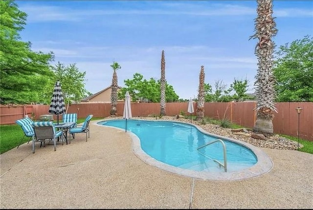 view of swimming pool with a patio area, outdoor dining area, a fenced backyard, and a fenced in pool