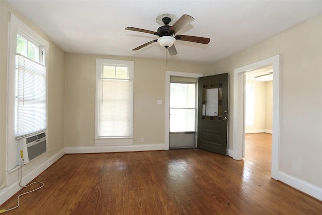 spare room featuring cooling unit, baseboards, ceiling fan, and wood finished floors