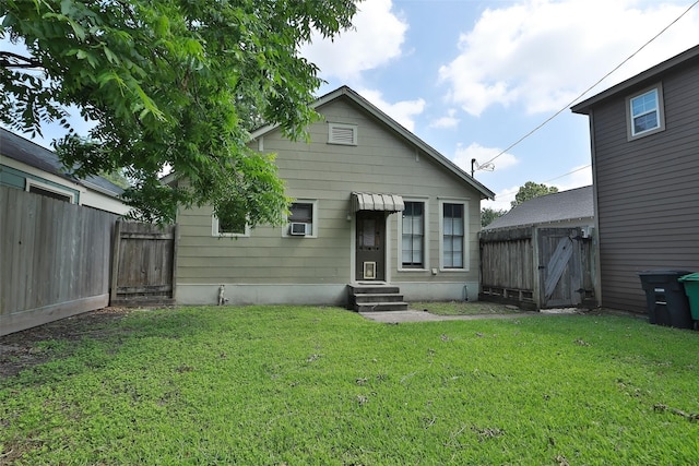 rear view of property featuring a yard, cooling unit, fence private yard, and entry steps