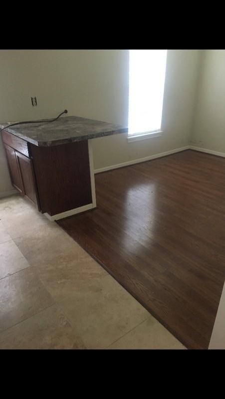 spare room featuring baseboards and light wood-style flooring