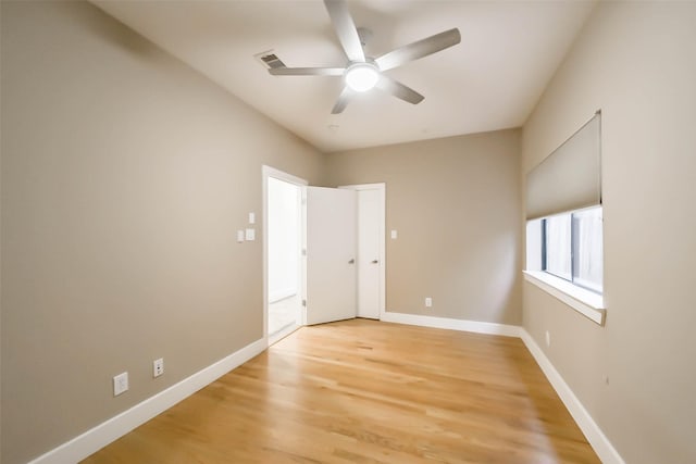 spare room with light wood-style flooring, visible vents, baseboards, and ceiling fan