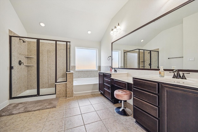 bathroom with double vanity, vaulted ceiling, a shower stall, a garden tub, and tile patterned floors