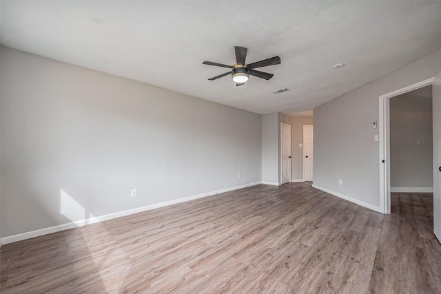 unfurnished room with visible vents, baseboards, wood finished floors, and a ceiling fan