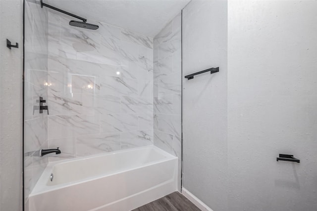 bathroom with shower / tub combination, wood finished floors, and baseboards