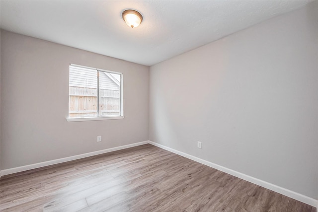 empty room featuring baseboards and wood finished floors