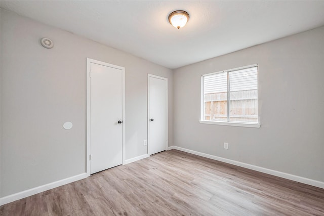 unfurnished bedroom with wood finished floors and baseboards